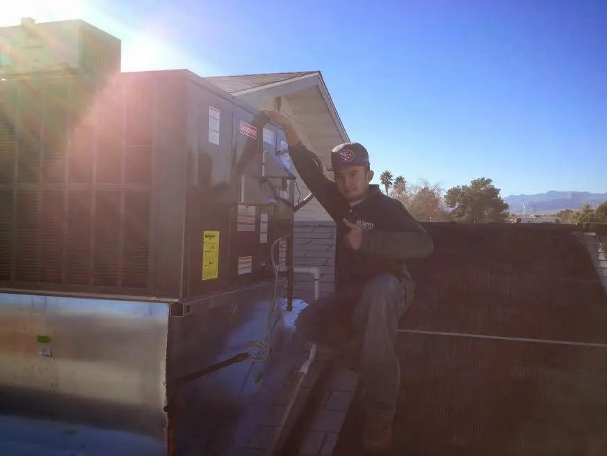 HVAC technician performing AC Tune-Up on a rooftop unit in Fairview Park